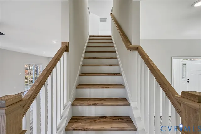 an empty room with wooden floor fireplace and window