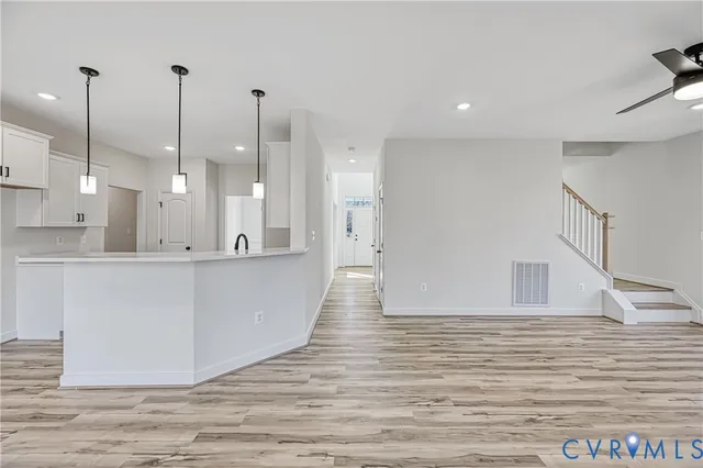 a view of a kitchen with white cabinets and stainless steel appliances