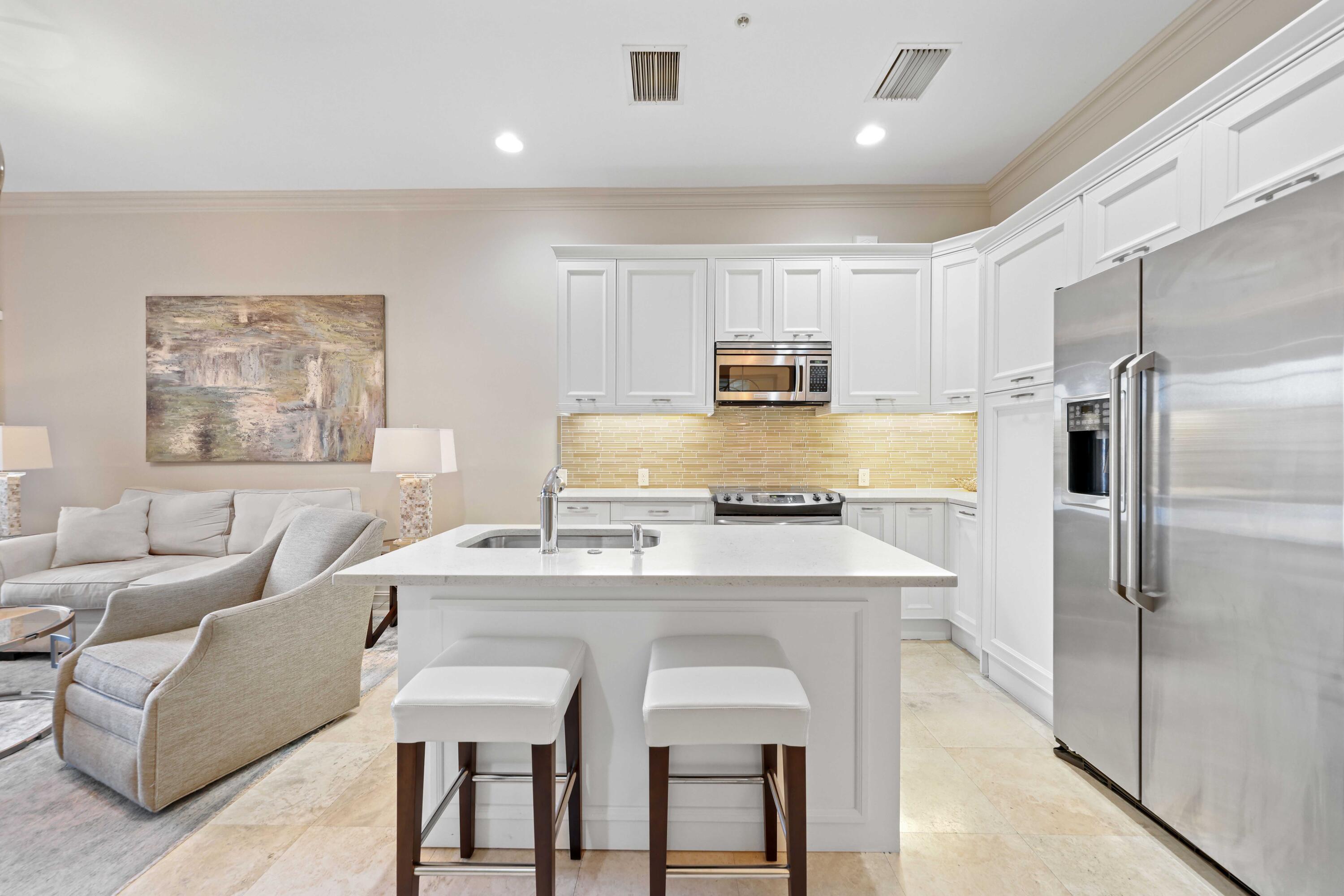 a kitchen with kitchen island a counter top space cabinets and stainless steel appliances