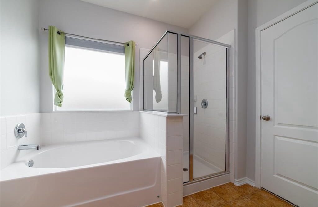 7013 Lickeen Court Austin, TX 78744 - Photo 8 of 20 a bathroom with a bathtub and a shower