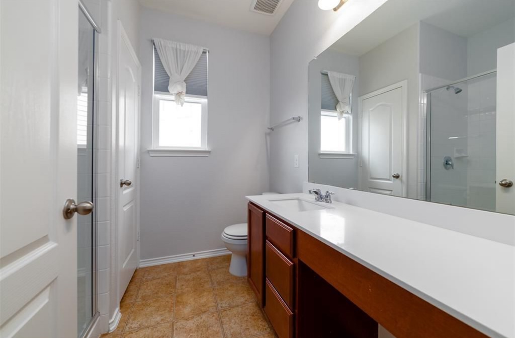 7013 Lickeen Court Austin, TX 78744 - Photo 11 of 20 a bathroom with a sink a toilet and shower