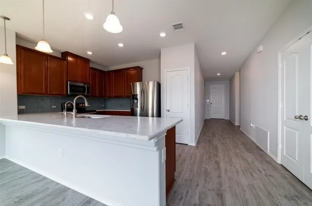 a kitchen with stainless steel appliances granite countertop wooden cabinets a stove a sink and dishwasher
