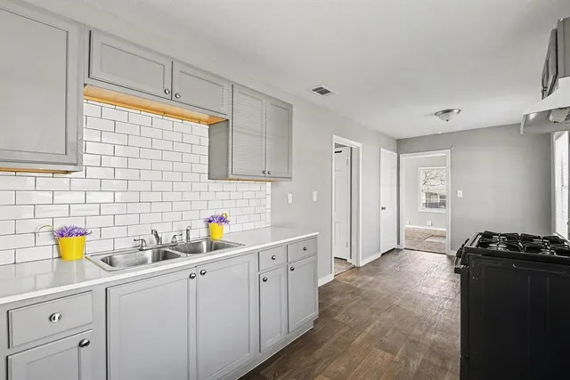 a kitchen with a sink a stove cabinets and counter space