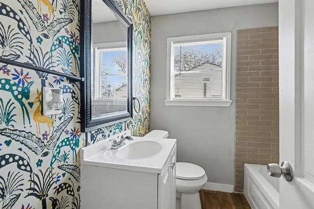 a bathroom with a sink and mirror with toilet
