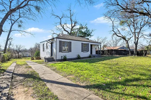a view of a house with backyard and trees