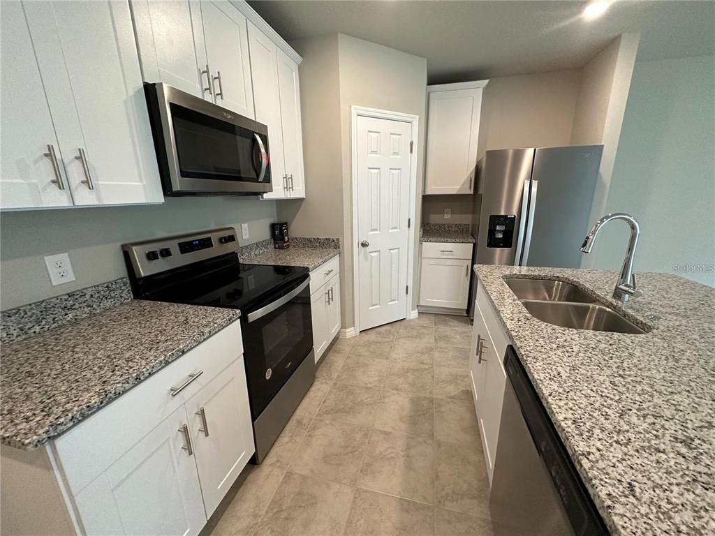 430 Legacy Loop Davenport, FL 33896 - Photo 6 of 21 a kitchen with stainless steel appliances granite countertop a sink stove and refrigerator