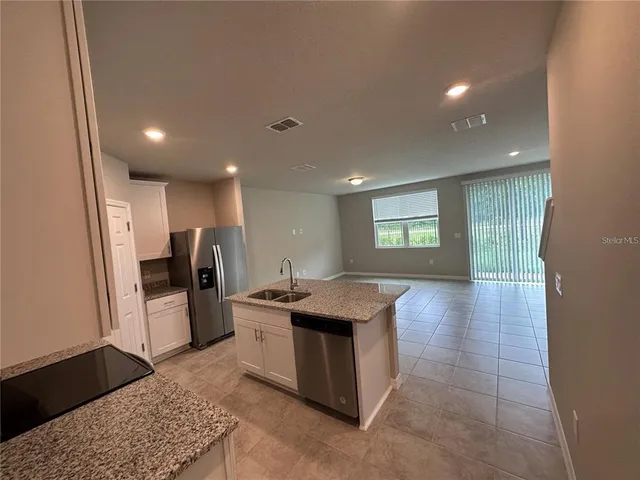 a large kitchen with stainless steel appliances lots of counter space and breakfast area