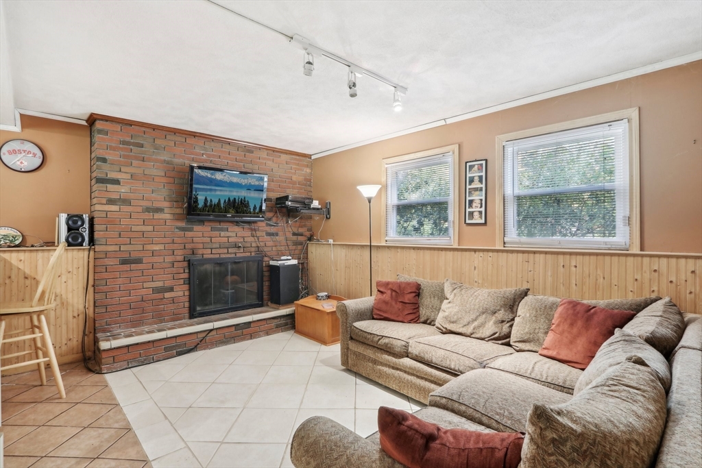 128 Harvard Road Stow, MA 01775 - Photo 17 of 36 a living room with furniture a flat screen tv and a fireplace