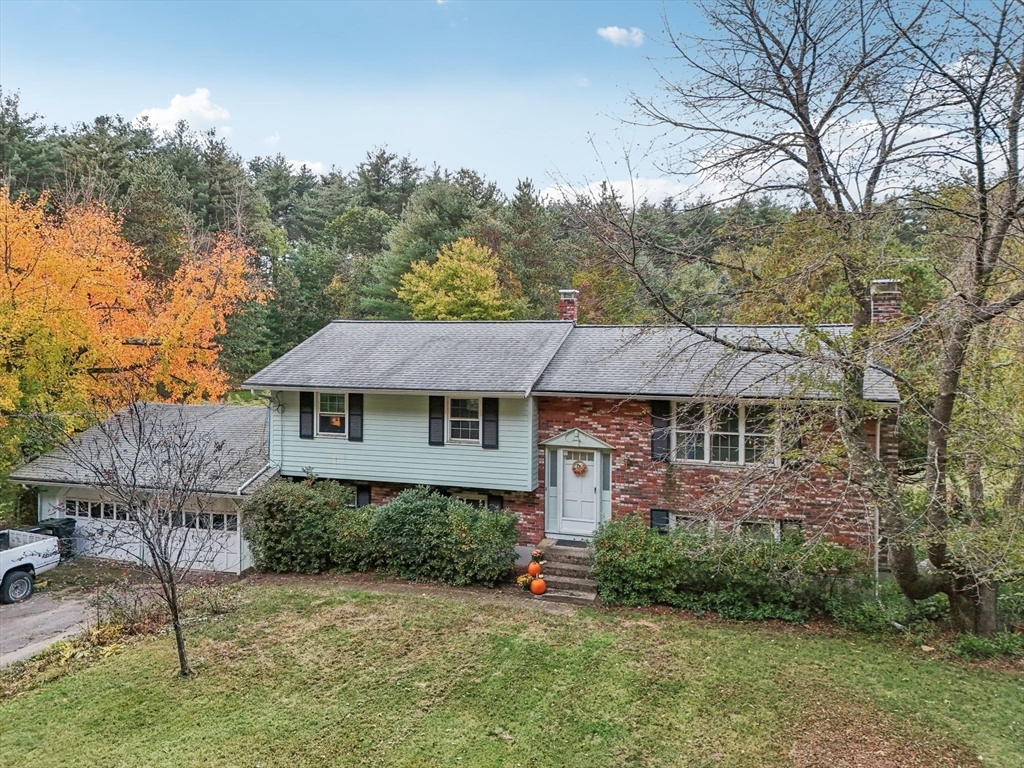 128 Harvard Road Stow, MA 01775 - Photo 2 of 36 a backyard of a house with plants and large tree