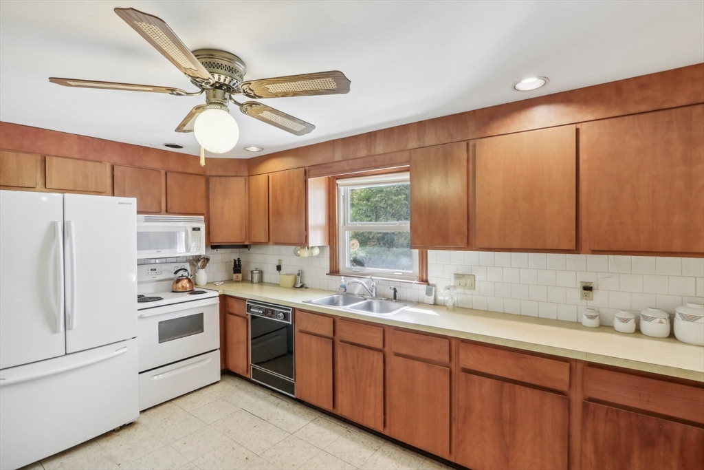128 Harvard Road Stow, MA 01775 - Photo 10 of 36 a kitchen with a sink a refrigerator and cabinets
