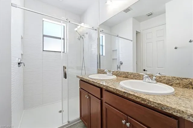 a bathroom with a granite countertop sink mirror and double