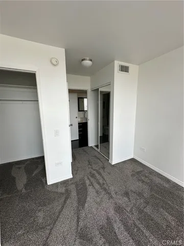 a view of a kitchen with refrigerator and white wall