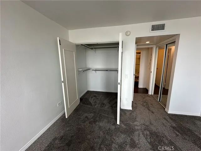 a view of empty room with wooden floor and cabinet