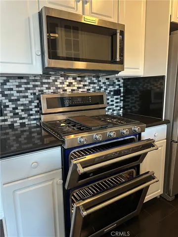 a view of kitchen with a stove and a microwave