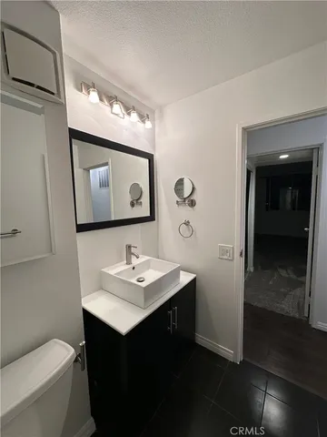 a bathroom with a sink vanity mirror and toilet