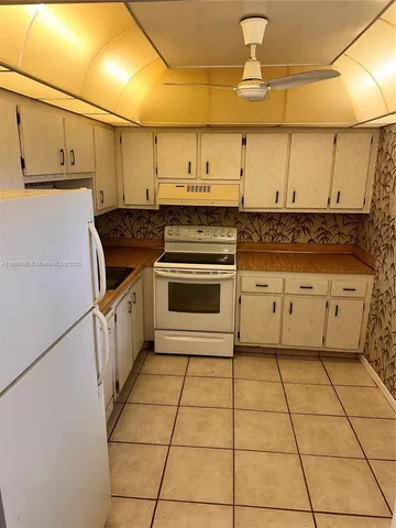 a kitchen with granite countertop a stove a sink and a refrigerator