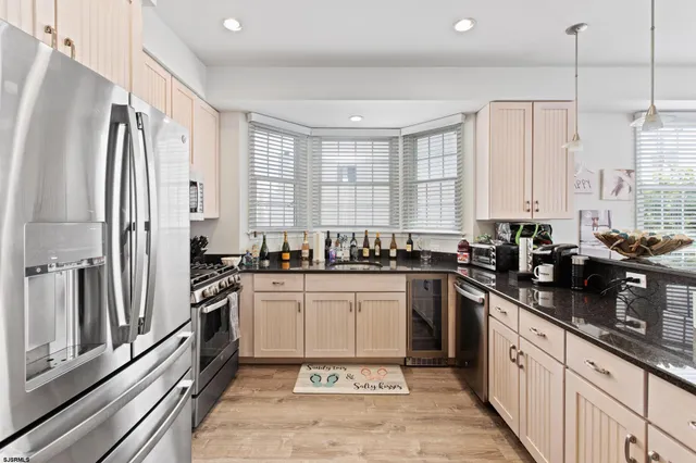 a large kitchen with stainless steel appliances granite countertop a sink stove and refrigerator