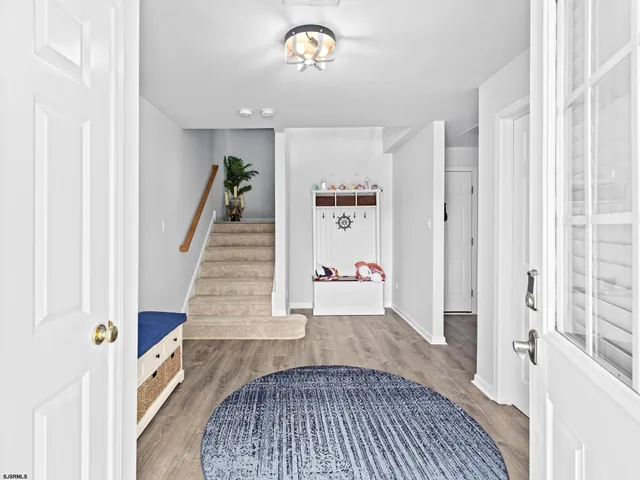 a view of entryway and hall with wooden floor