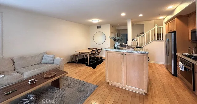 a living room with furniture a flat screen tv and a wooden floor