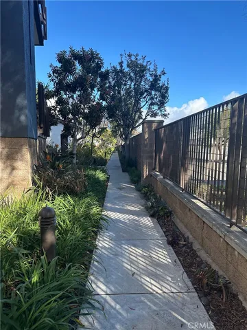 a view of a pathway with a wrought fence