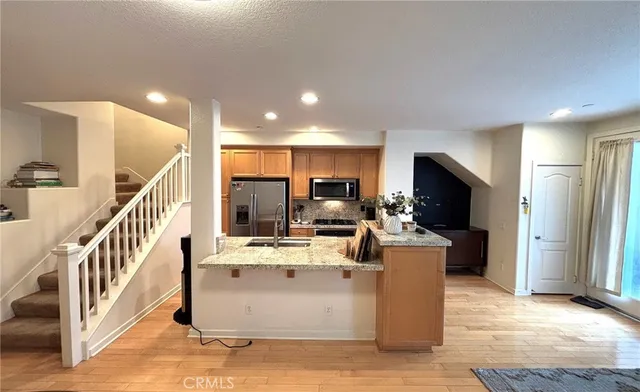 a living room with stainless steel appliances kitchen island furniture and a view of kitchen