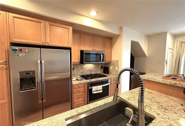 a kitchen with stainless steel appliances granite countertop a refrigerator and a stove