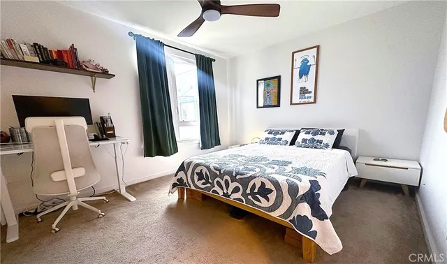 a bedroom with a bed a chair and painting on the wall