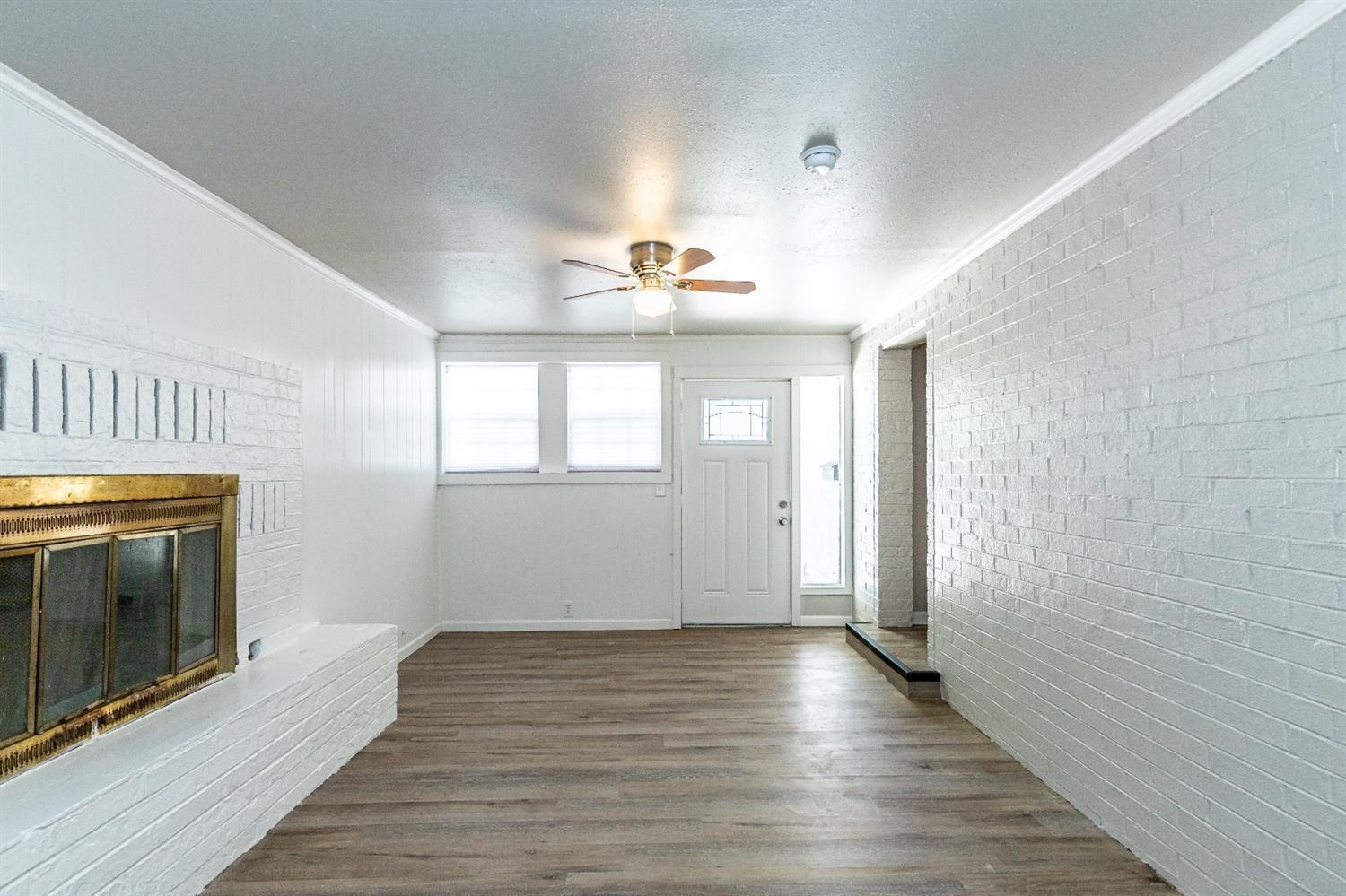 2723 66th Street Lubbock, TX 79413 - Photo 4 of 17 a view of empty room with wooden floor and fan