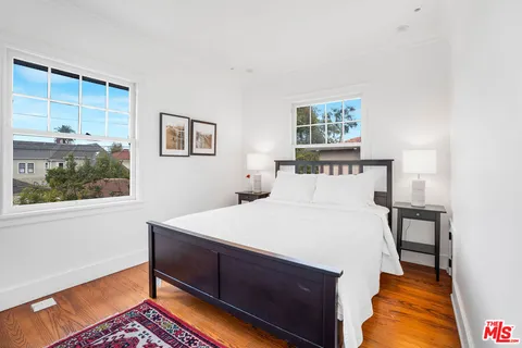 a bedroom with two beds and painting on the wall