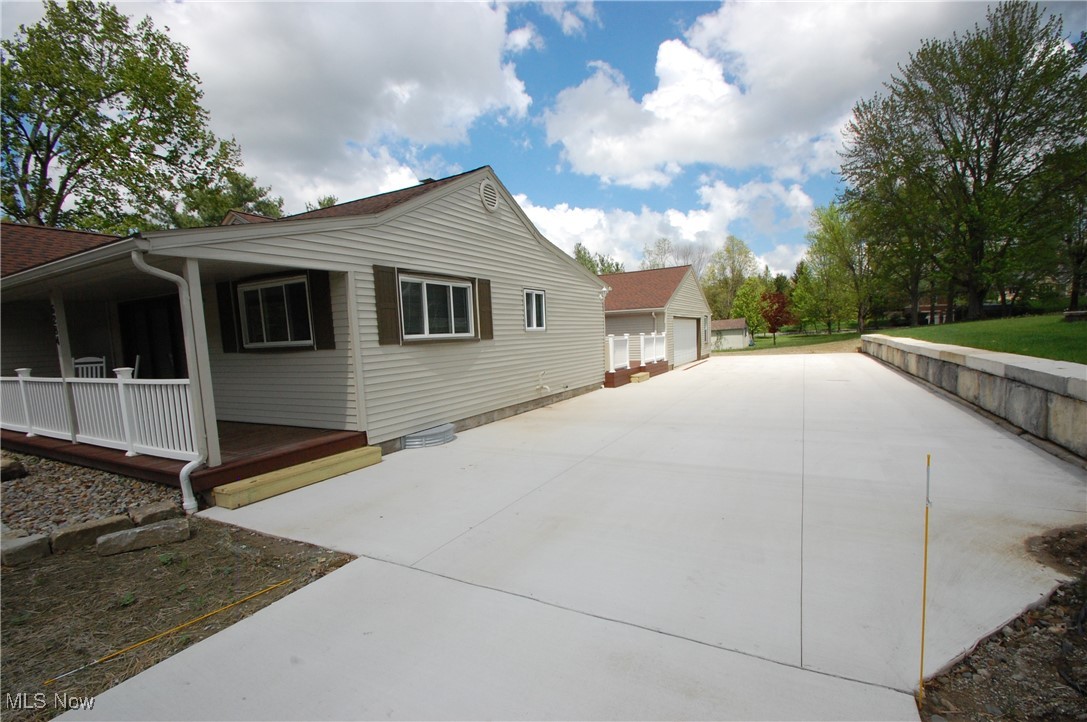 View of property exterior with covered porch and a detached garage