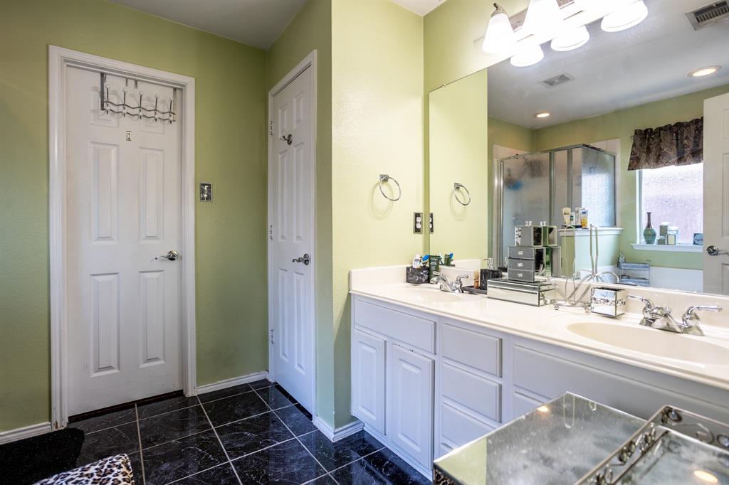 928 Trinity Drive Lancaster, TX 75146 - Photo 26 of 31 a bathroom with a double vanity sink a mirror and a shower