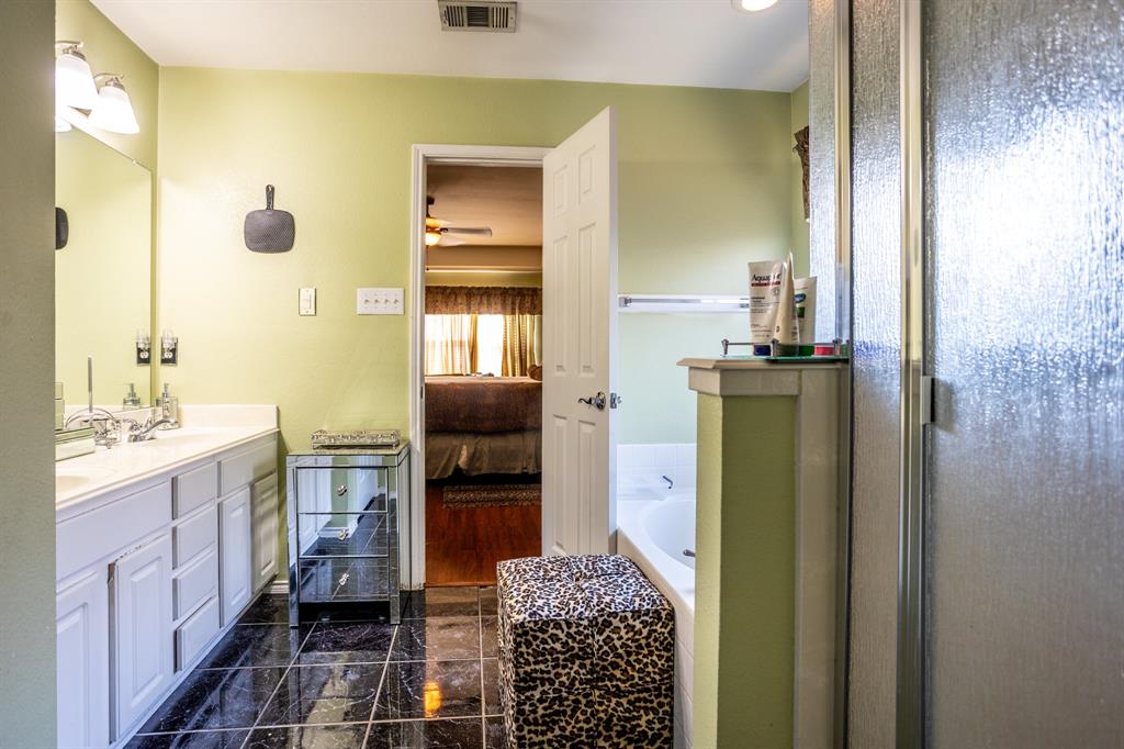 928 Trinity Drive Lancaster, TX 75146 - Photo 28 of 31 a bathroom with a granite countertop sink a mirror and shower