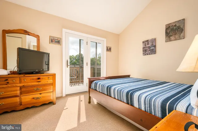 a bedroom with a bed and two night stand next to a window