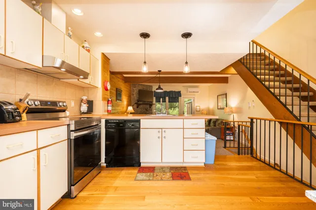 a kitchen with stainless steel appliances kitchen island granite countertop a stove a sink and a refrigerator