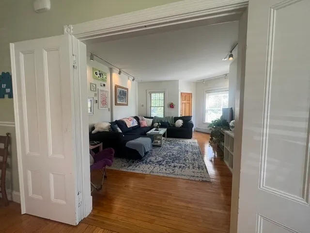 a living room with furniture and a wooden floor