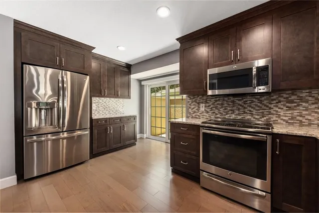 a kitchen with granite countertop stainless steel appliances and wooden cabinets
