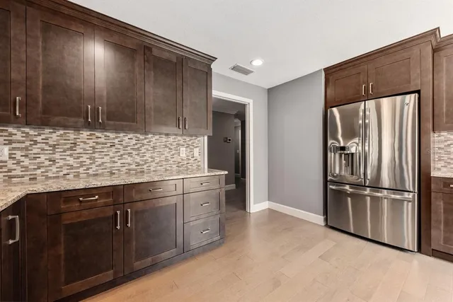 a kitchen with stainless steel appliances granite countertop a refrigerator and a sink