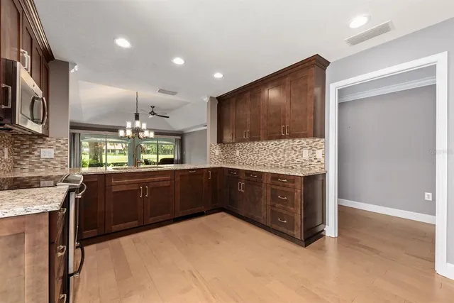 a kitchen with stainless steel appliances kitchen island granite countertop a stove and a sink