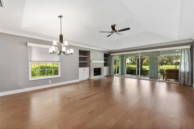 a view of empty room with wooden floor and fireplace