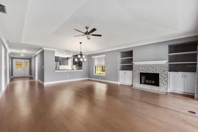 a view of an empty room with a fireplace and window