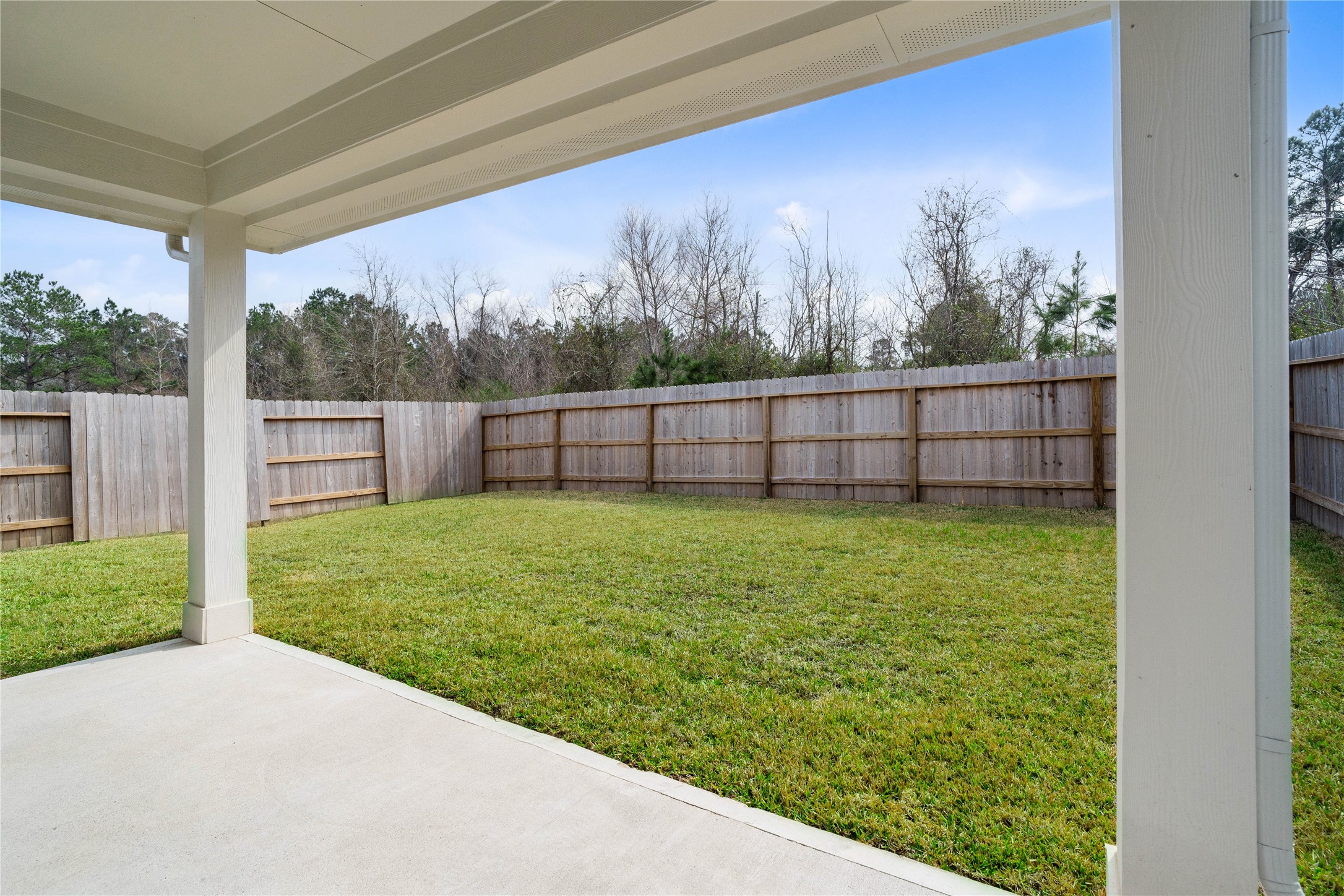 19555 Montgomery Rdg Way Montgomery, TX 77316 - Photo 30 of 38 The spacious covered patio offers a tranquil outdoor retreat, perfectly designed for savoring your quiet morning coffee or unwinding during peaceful evening relaxation.