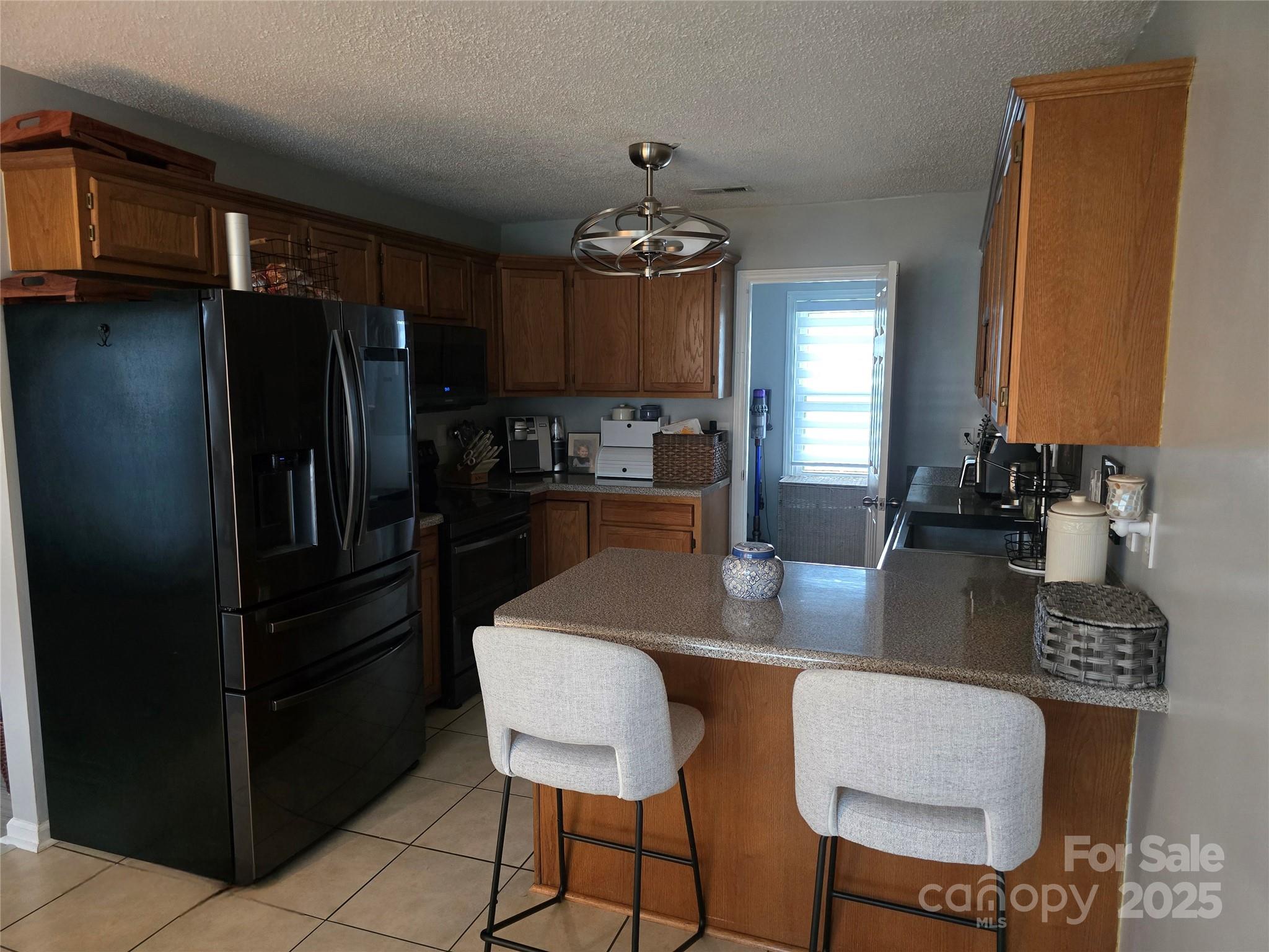 5202 Robin Lane Randleman, NC 27317 - Photo 24 of 48 a kitchen with stainless steel appliances granite countertop a refrigerator a sink a stove a dining table and chairs