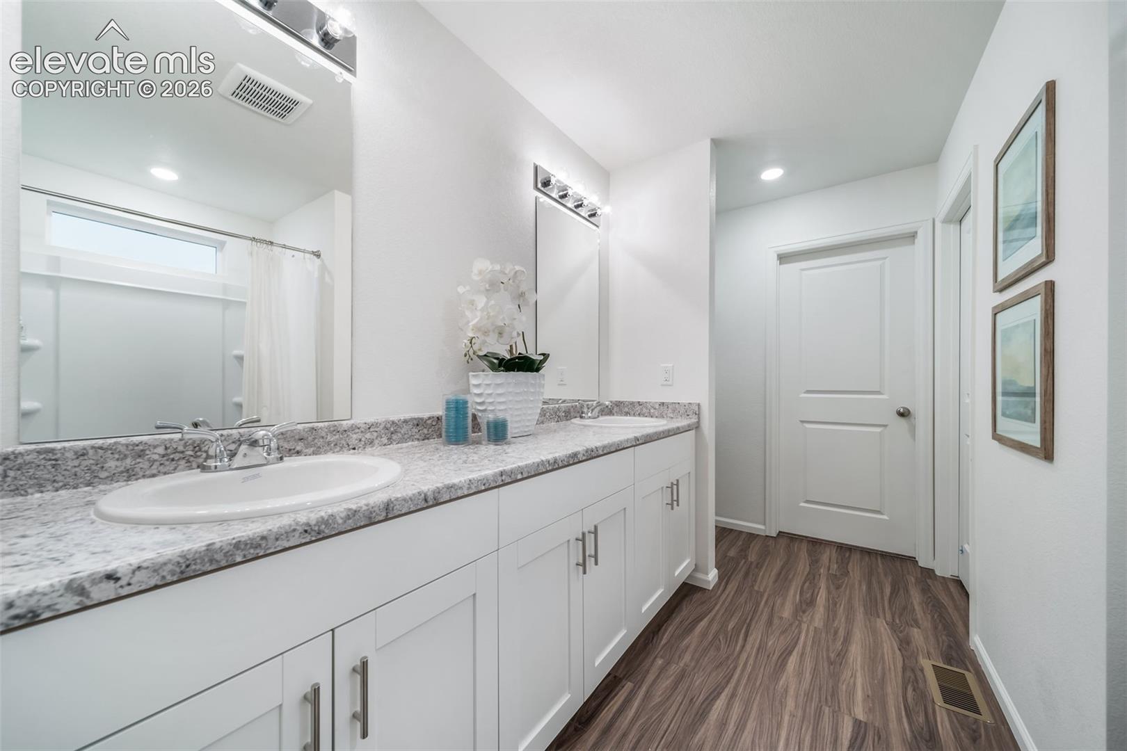 4936 Truscott Road Colorado Springs, CO 80925 - Photo 34 of 41 Dual vanity with white cabinetry, light-toned countertop, and undermount sinks
*photos of a model home*