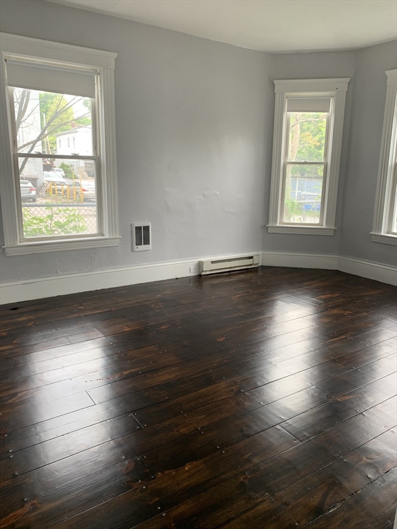 8 Knowlton Avenue, Unit 2 Worcester, MA 01603 - Photo 8 of 14 an empty room with wooden floor and windows