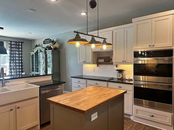 a kitchen with a sink a counter top space appliances and cabinets