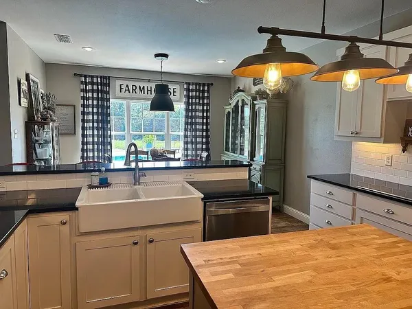 a kitchen with stainless steel appliances a sink a counter space and a view of living room