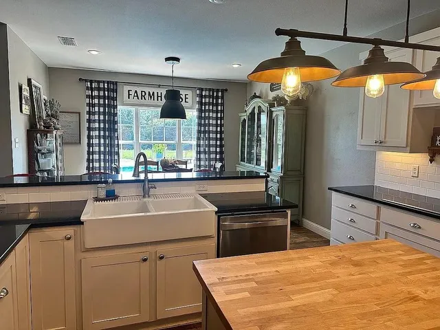 a kitchen with stainless steel appliances a sink a counter space and a view of living room