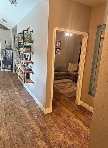 a view of a hallway with wooden floor and furniture