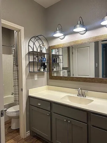 a en suite bathroom with a toilet a sink and a mirror