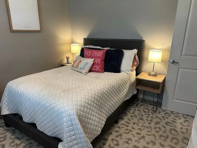 a bedroom with a bed and a lamp